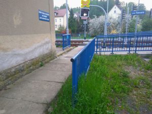 Zábradlí ve Vesci u Liberce mezi chodníkem a trávníkem. Foto: Jan Sůra