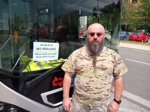 Radek Čejka před autobusem, v kterém informuje cestující o své mzdě. Jde o jednu z forem protestu proti nízkým mzdám. Foto: archív R. Čejky