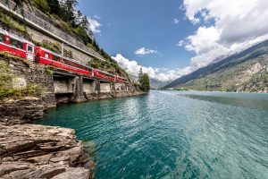 Bernina Express podél jezera Lago di Poschiavo. Foto: Rhätische Bahn