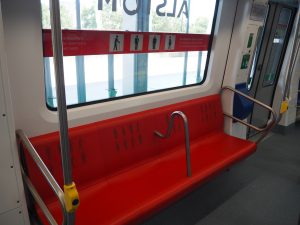 Červené sedadlo je vyhrazené pro seniory, uprostřed má madlo usnadňující držení. Foto: Jan Nevyhoštěný, Zdopravy.cz