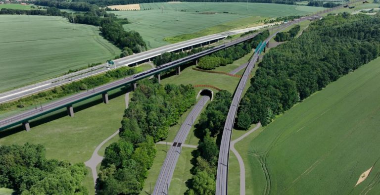VRT Moravská Brána II. Pohled na trať VRT, sjezdovou větev VRT směrem do Hranic na Moravě, ekodukt přes stávající koridorovou železniční trať a další úpravy, vlevo zástavba obce Střítež nad Ludinou. Foto: RT Next