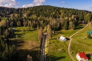 Pro představu, jakou krajinou vede zubačka, jeden dronový záběr od Subterry na kořenovský portál Polubenského tunelu. Odsud trať prudce klesá do Desné. Foto: Subterra