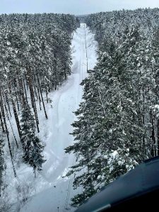 Polský policejní Black hawk shazuje sníh ze stromů v okolí tratě. Zdroj: Polska Policja